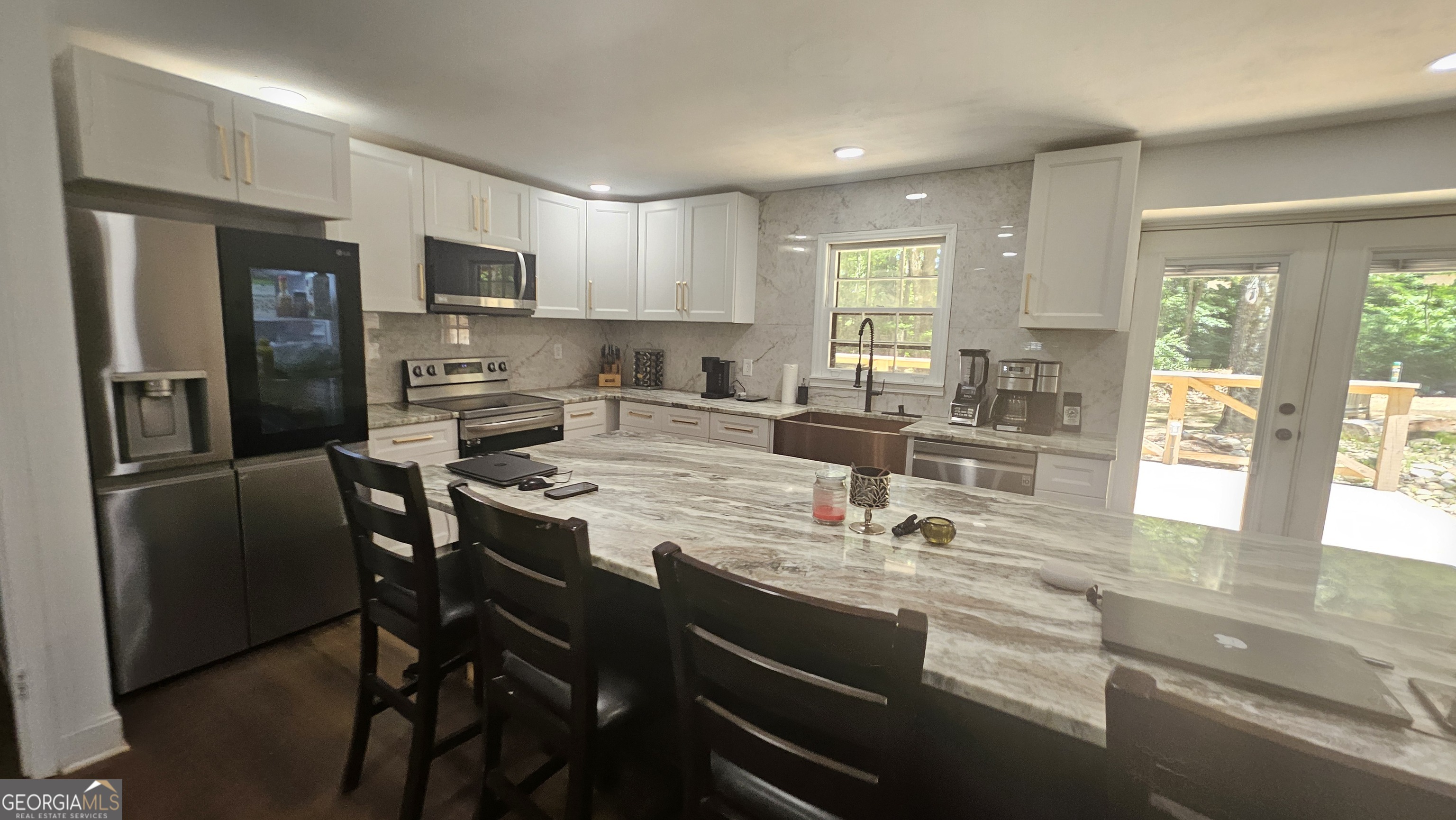 4360 Stonewall Tell Road College Park, GA 30349 - Photo 7 of 49 a kitchen with stainless steel appliances kitchen island granite countertop a refrigerator a stove a sink a dining table and chairs with wooden floor
