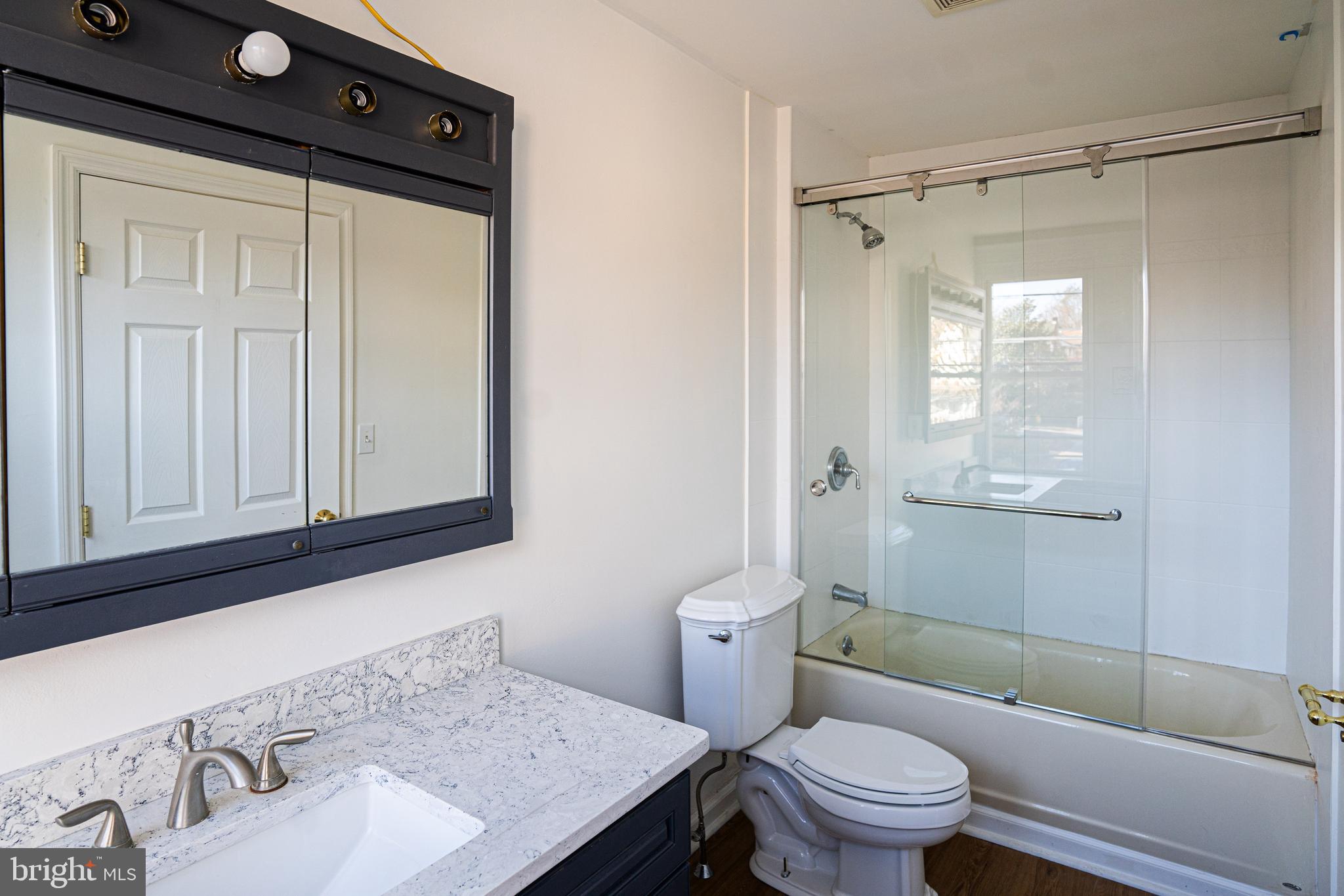 2540 East County Line Road Ardmore, PA 19003 - Photo 13 of 22 a bathroom with a granite countertop sink toilet and shower