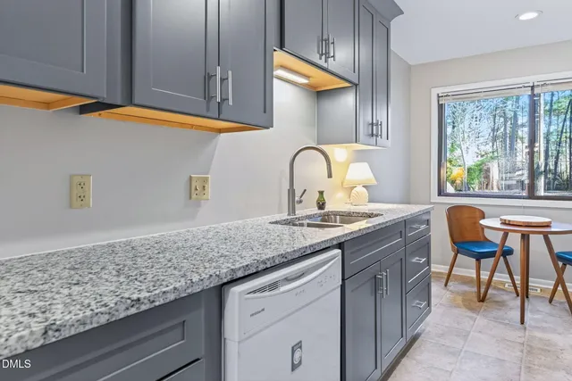 a kitchen with granite countertop lots of counter top space and windows