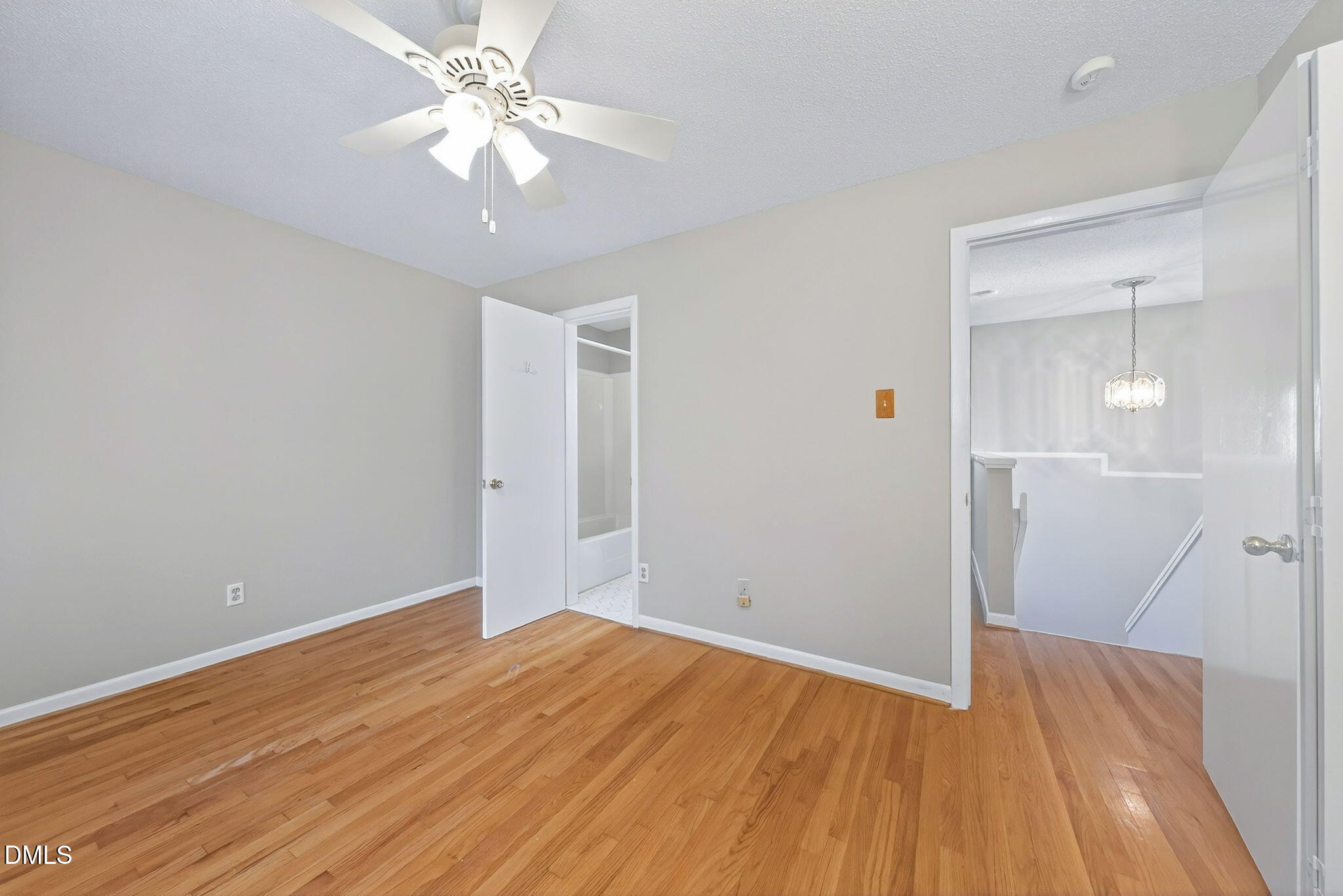 216 Ridge Trail Chapel Hill, NC 27516 - Photo 24 of 30 an empty room with wooden floor and a chandelier fan