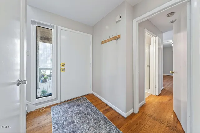 a view of a hallway with wooden floor windows and a livingroom