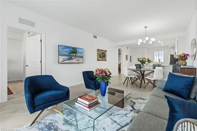 a living room with furniture a chandelier and a window