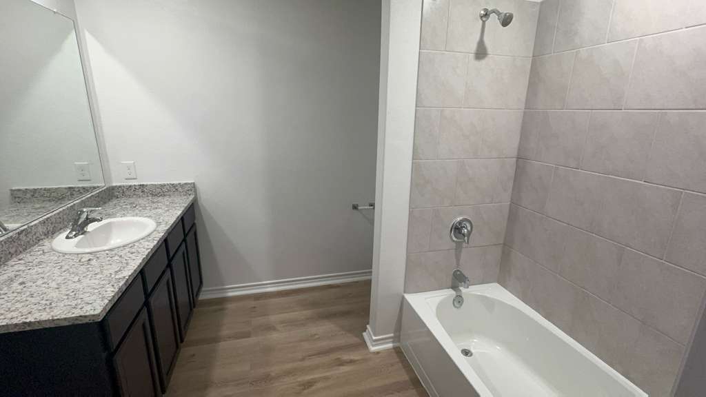 14205 Prairie Sod Lane Elgin, TX 78621 - Photo 10 of 24 a bathroom with a granite countertop sink and bathtub