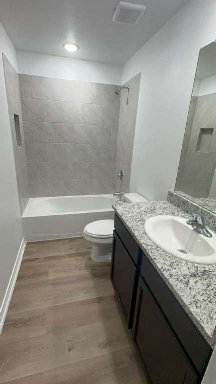 14205 Prairie Sod Lane Elgin, TX 78621 - Photo 16 of 24 a bathroom with a granite countertop sink a toilet and bathtub