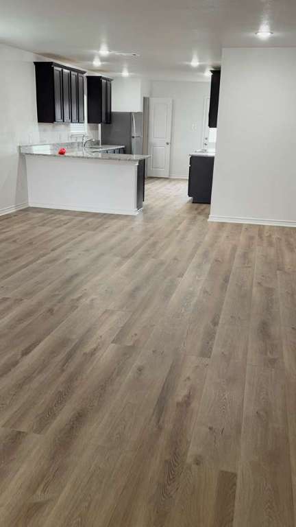 14205 Prairie Sod Lane Elgin, TX 78621 - Photo 3 of 24 a large white kitchen with kitchen island a sink dishwasher a oven with white cabinets and wooden floor