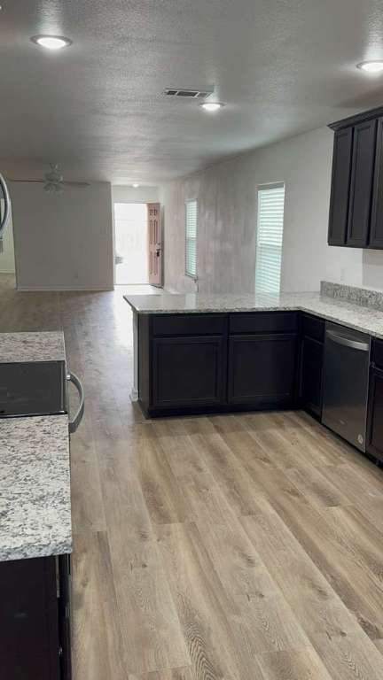 14205 Prairie Sod Lane Elgin, TX 78621 - Photo 24 of 24 a kitchen with stainless steel appliances granite countertop a refrigerator a stove and wooden cabinets