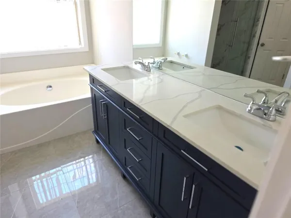 a bathroom with a tub sink and mirror