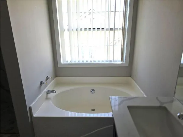 a bath tub sitting in a bathroom next to a window