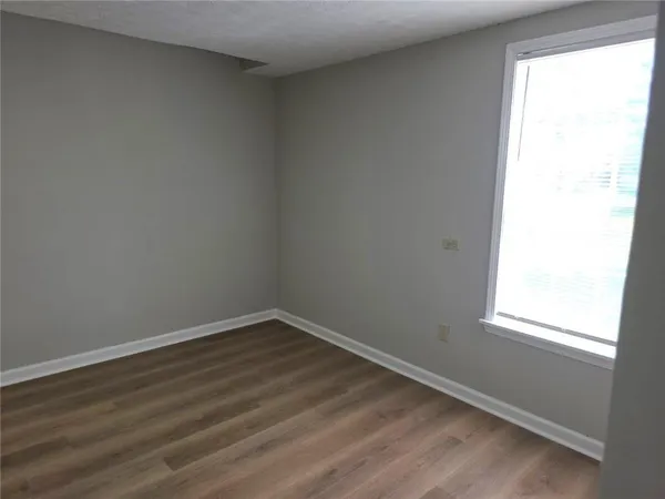 an empty room with wooden floor and window