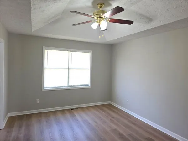 an empty room with a window and a fan