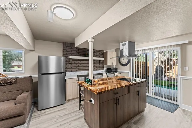 a kitchen with stainless steel appliances granite countertop a stove a refrigerator and a more cabinets