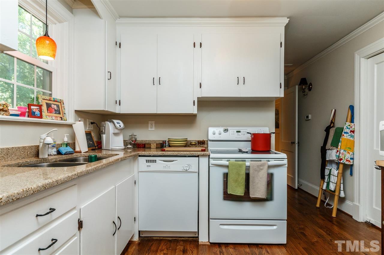 2509 Wake Drive Raleigh, NC 27608 - Photo 22 of 25 a kitchen with kitchen island granite countertop wooden cabinets and a stove