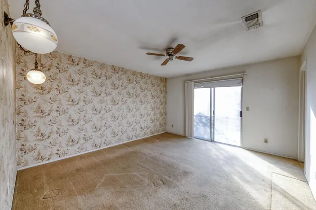 a view of a room with a sink and chandelier fan