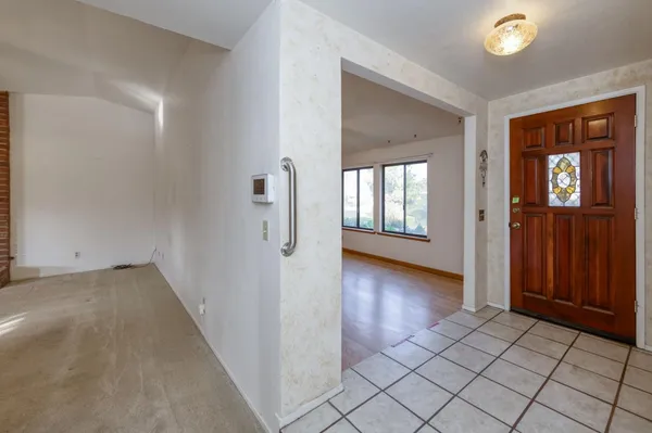 a view of a hallway with wooden floor and windows