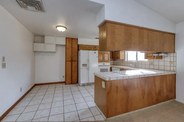 a kitchen with stainless steel appliances granite countertop a sink a stove and a refrigerator