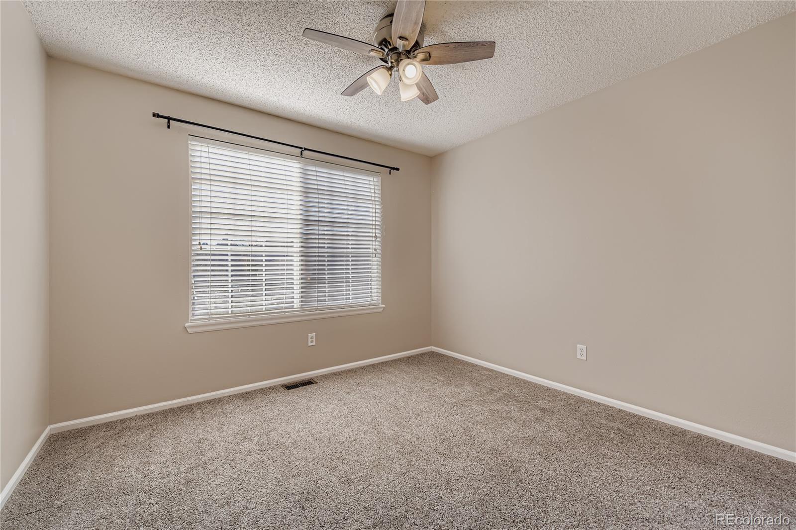 4927 Tarcoola Lane Highlands Ranch, CO 80130 - Photo 12 of 20 an empty room with windows and fan