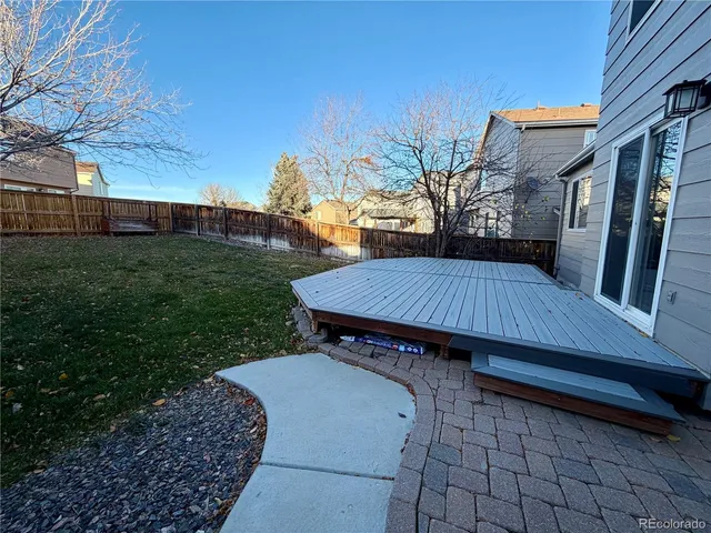 a view of backyard with deck and outdoor seating