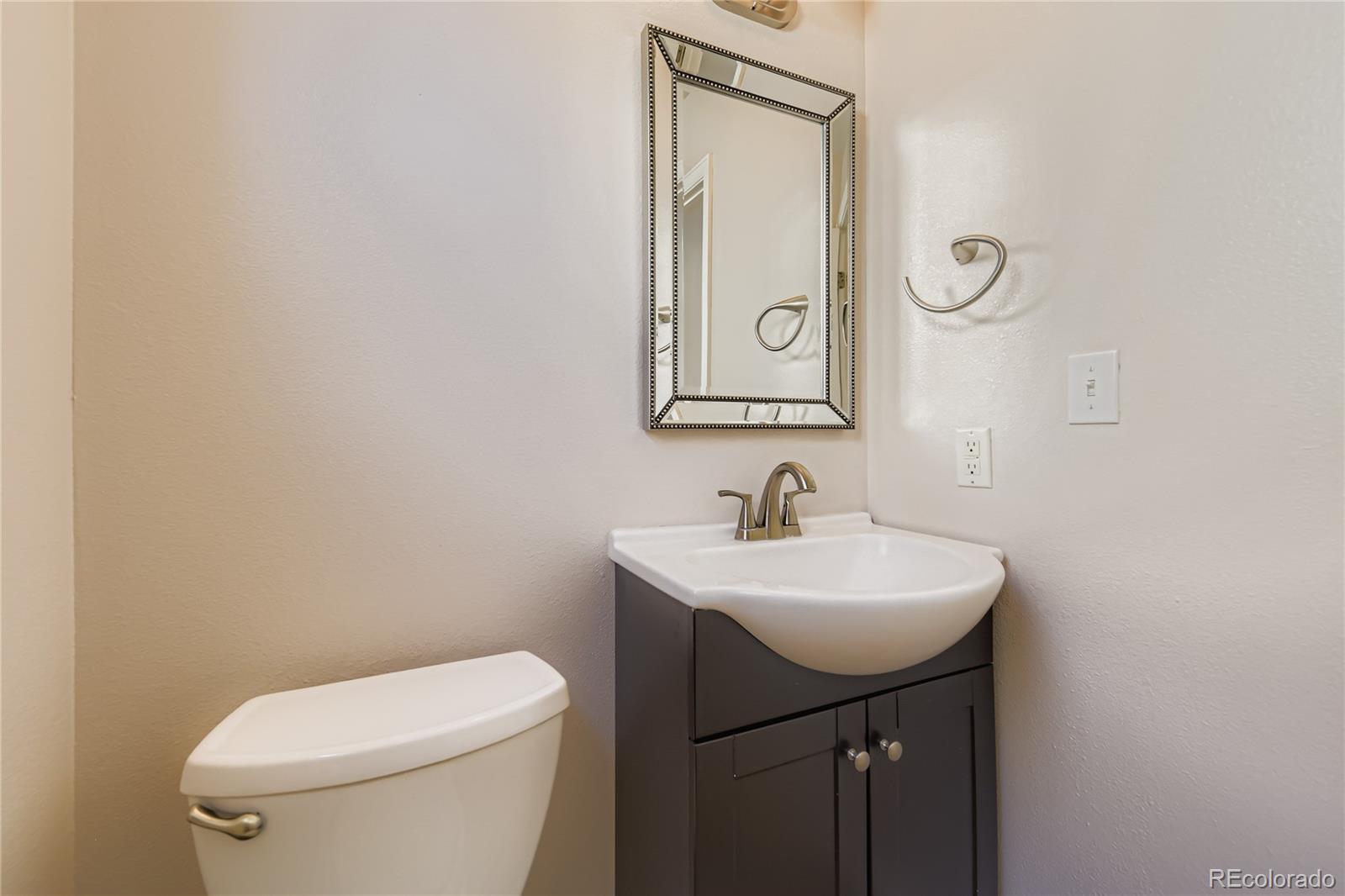 4927 Tarcoola Lane Highlands Ranch, CO 80130 - Photo 8 of 20 a bathroom with a toilet sink and mirror