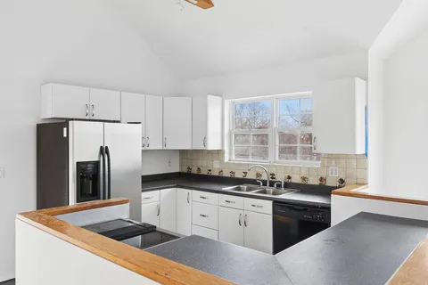 a kitchen with granite countertop a sink stove and refrigerator