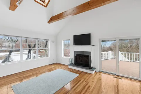 a view of empty room with wooden floor and fireplace