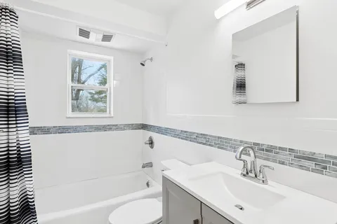 a bathroom with a bathtub a sink a mirror and a shower