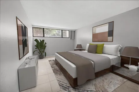 a bedroom with bed and a potted plant on dresser