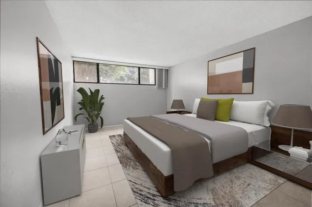 a bedroom with bed and a potted plant on dresser