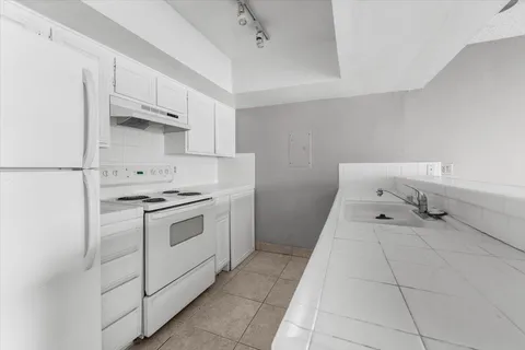 a kitchen with granite countertop a sink and a stove