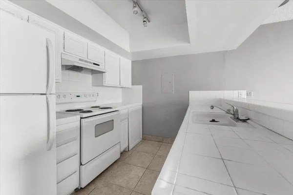 a kitchen with granite countertop a sink and a stove