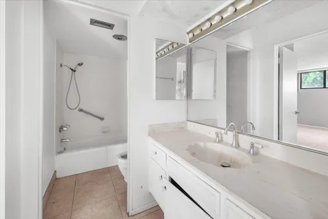 a bathroom with a tub sink double vanity and mirror