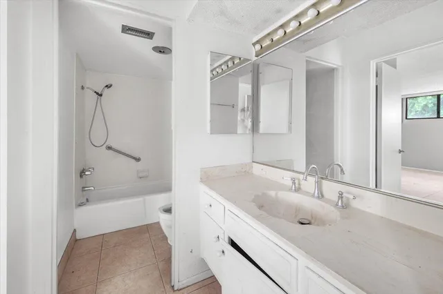 a bathroom with a tub sink double vanity and mirror