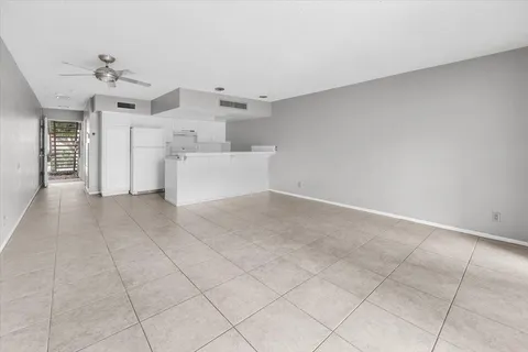 an empty room with windows and ceiling fan