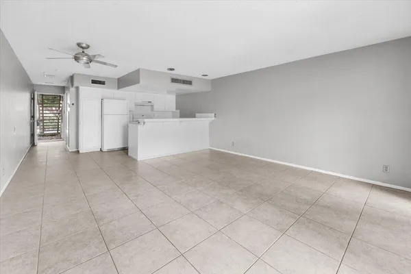 an empty room with windows and ceiling fan