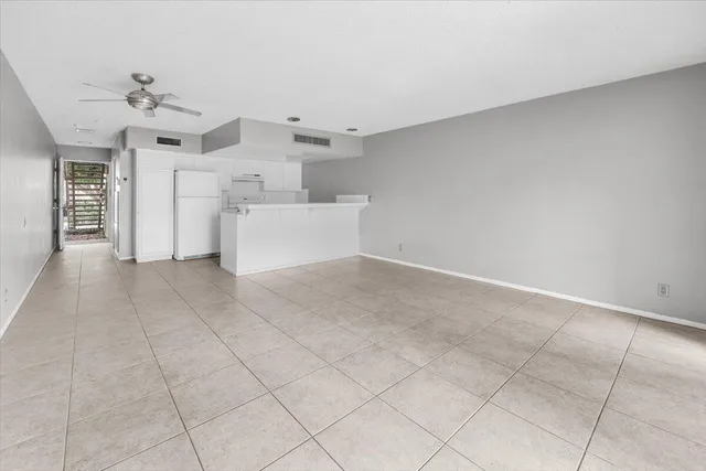 an empty room with windows and ceiling fan