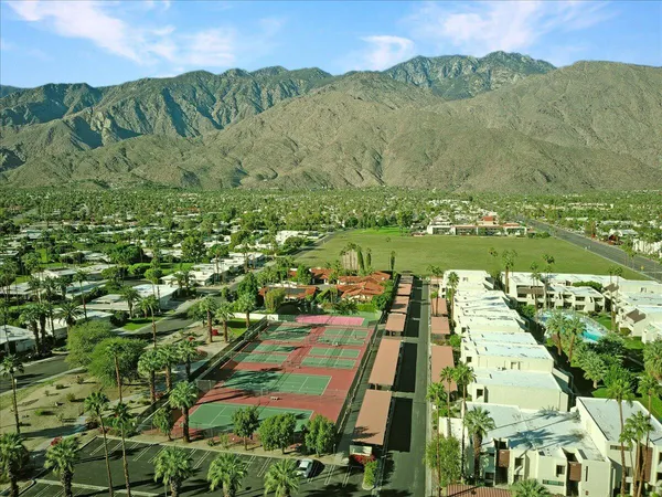 an aerial view of residential houses with outdoor space and trees