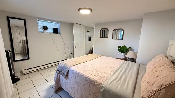 a bedroom with a large bed and wooden floor