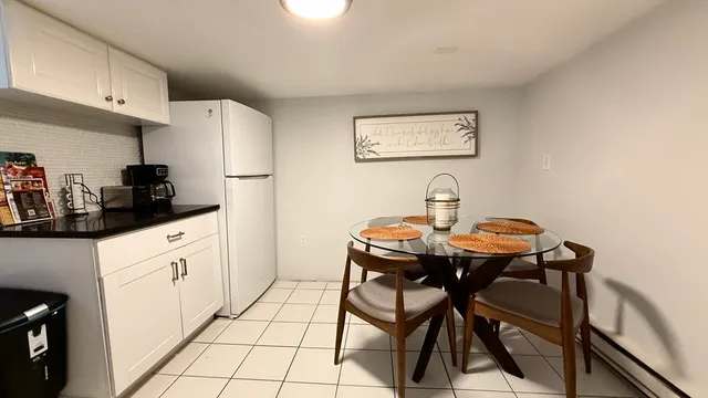 a kitchen with stainless steel appliances a white table and chairs in it