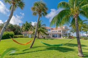 901 Southeast Riverside Drive Stuart, FL 34994 - Photo 30 of 53 a view of a swimming pool with a garden and palm trees