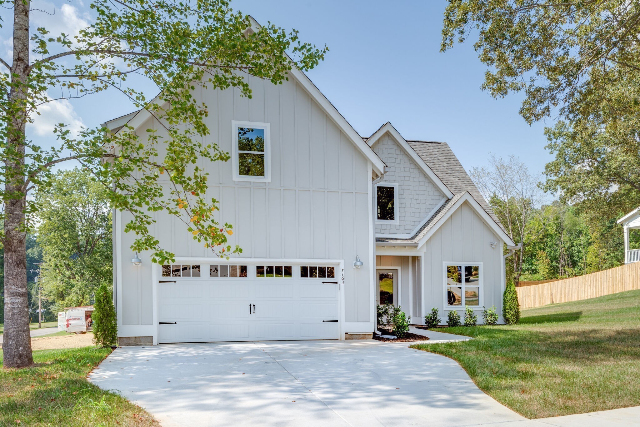 a front view of a house with a yard and trees