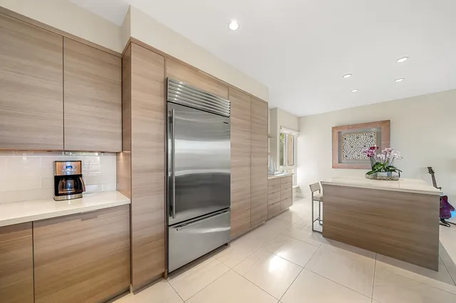 a large kitchen with kitchen island granite countertop a sink and white cabinets