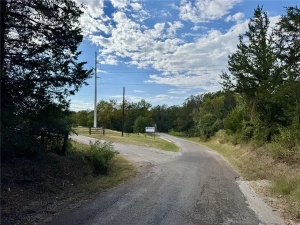 a view of dirt yard with large trees