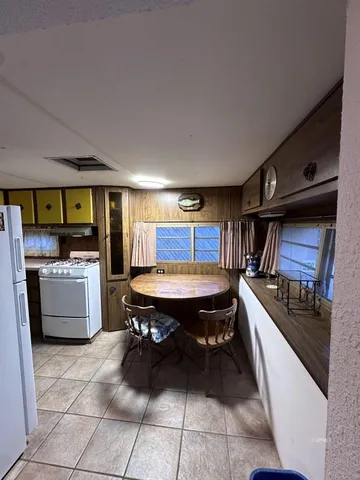 a room with furniture a flat screen tv and kitchen view