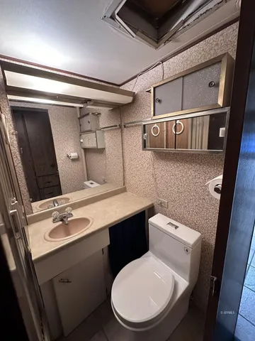 a bathroom with a toilet sink and mirror