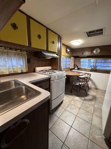 a kitchen with a sink a stove and cabinets