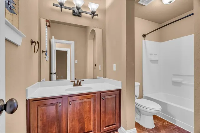 a spacious bedroom with a bed a dresser and windows