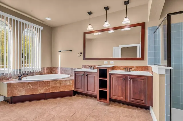 an empty room with chandelier fan and windows