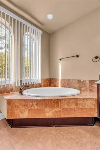 a spacious bathroom with a tub sink and mirror