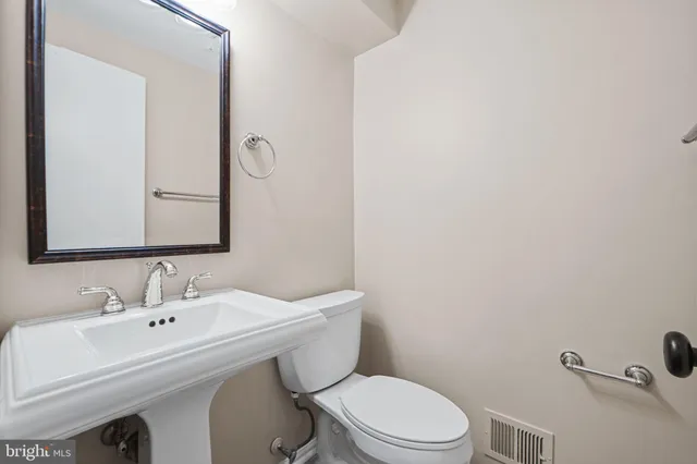 a bathroom with a sink a toilet and mirror