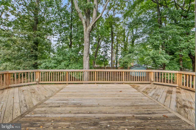 a view of deck with a fence and trees