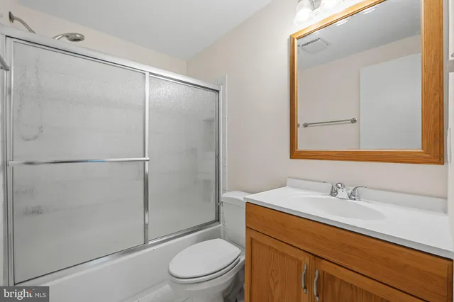 a bathroom with a sink a mirror a toilet and shower